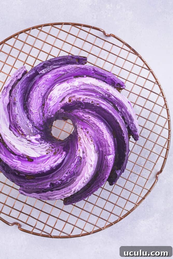 Ube cake — crème fraîche Bundt cake with ombré purple ube glaze on a wire cooling rack, overhead shot