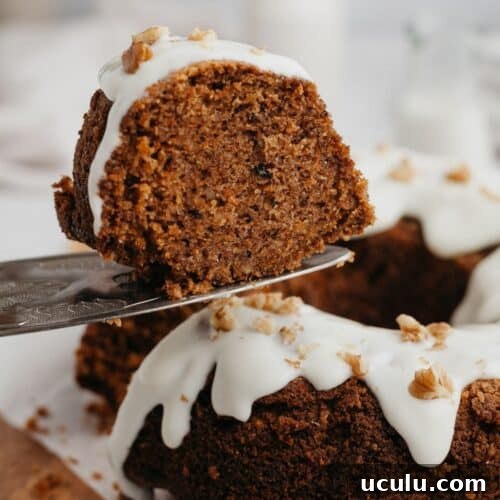 A slice of carrot bundt cake being lifted with a silver cake server.