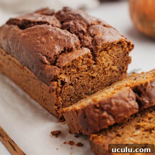 A pumpkin banana bread with several slices cut.