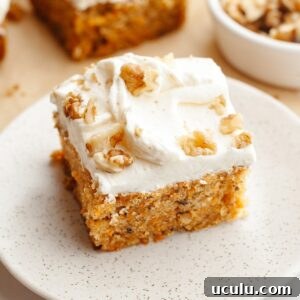 A slice of mini carrot cake with cream cheese frosting and chopped walnuts.