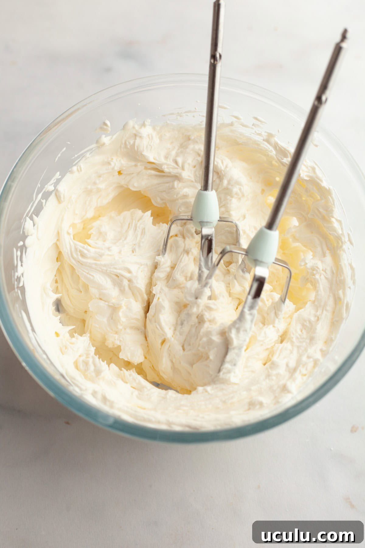 Cream cheese frosting in a glass bowl.