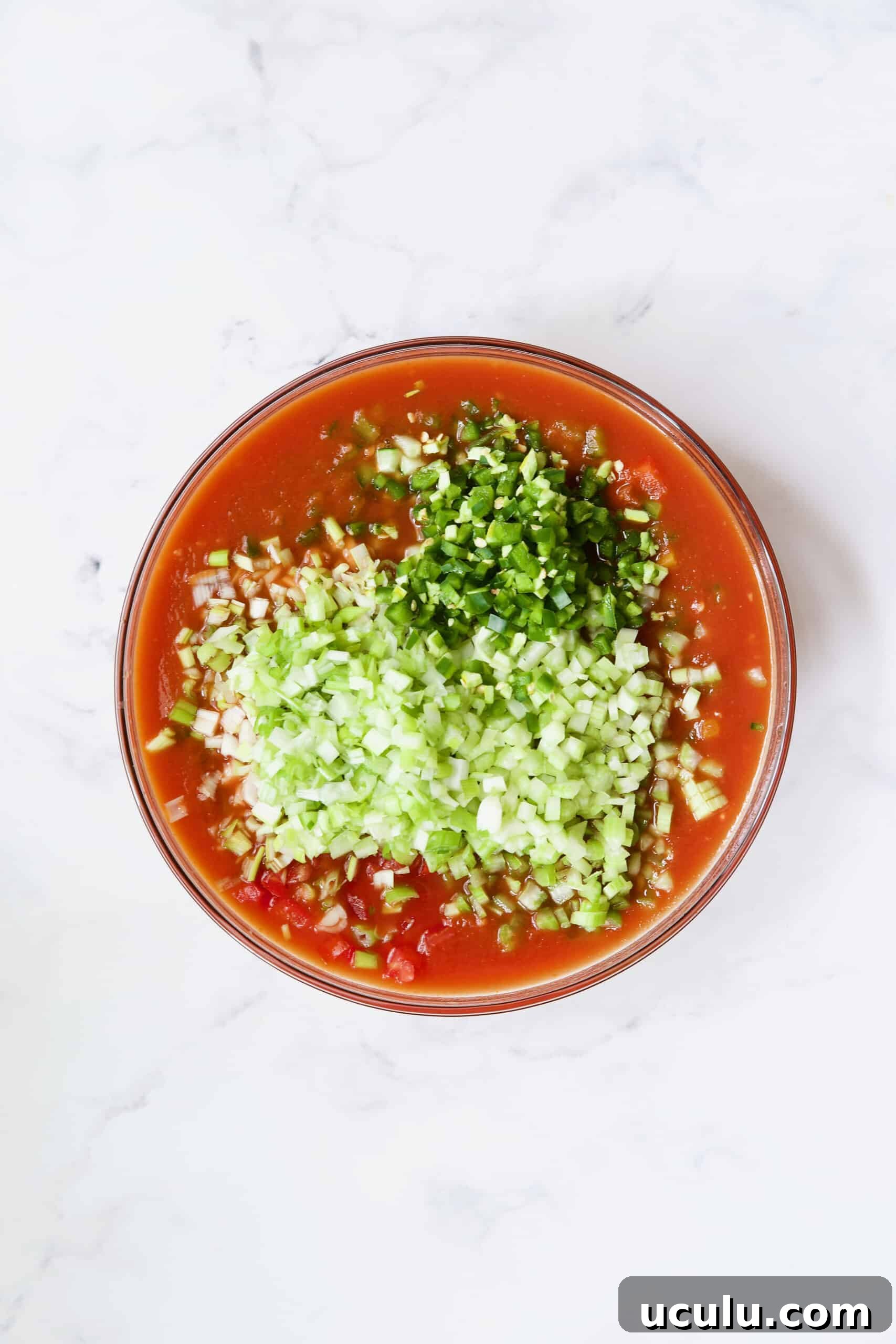 Ingredients for Very Veggie Gazpacho being combined in glass bowl.