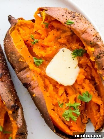 An air fryer baked sweet potato, cut in half with butter on it.