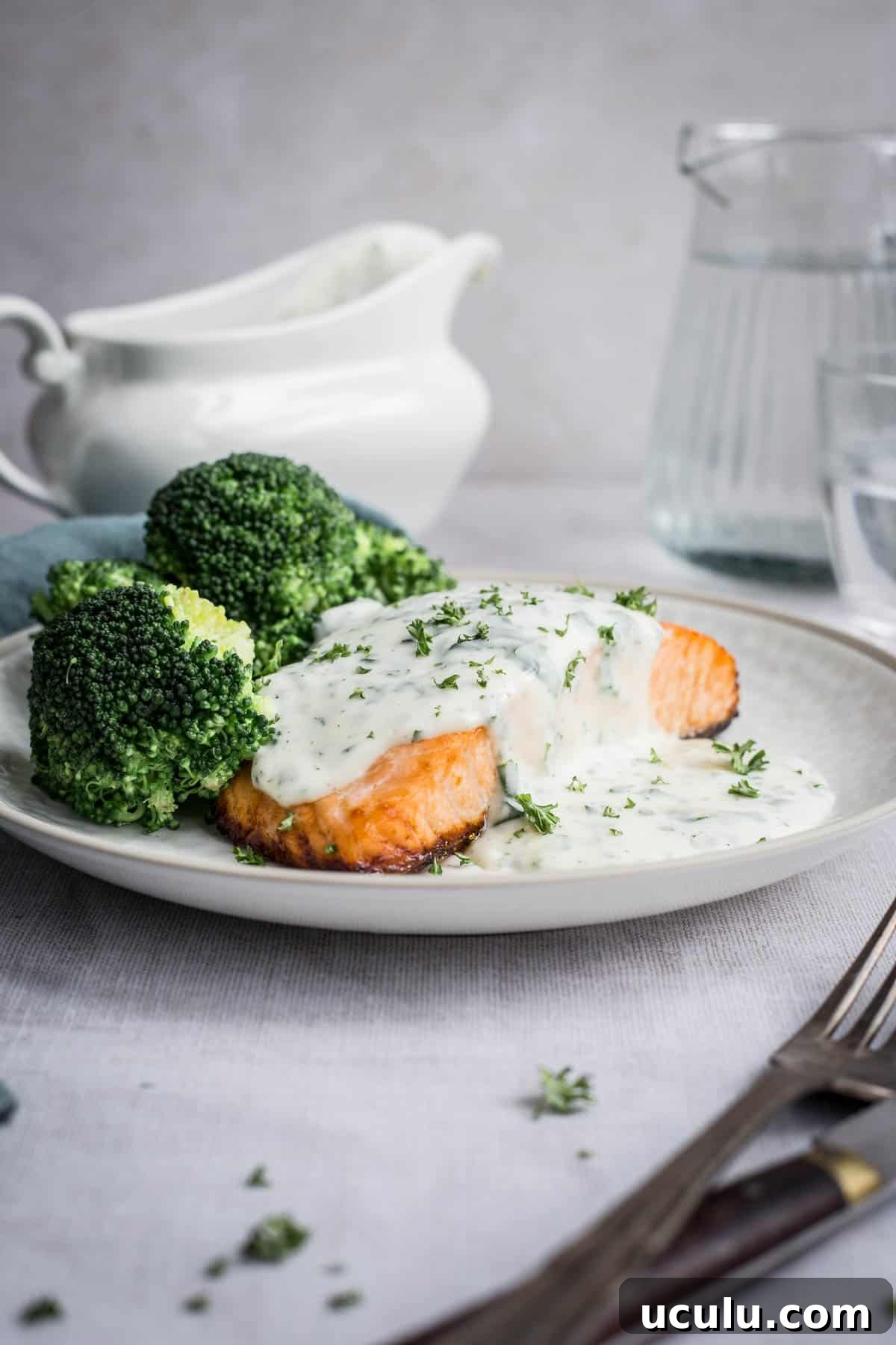 Parsley sauce drizzled over salmon and broccoli on a plate