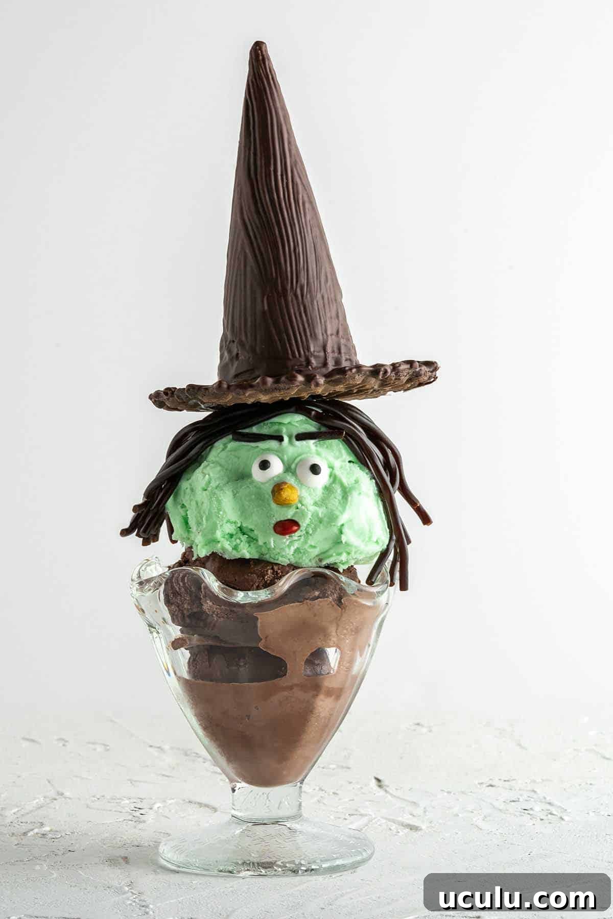side view of witch Halloween sundae with white background
