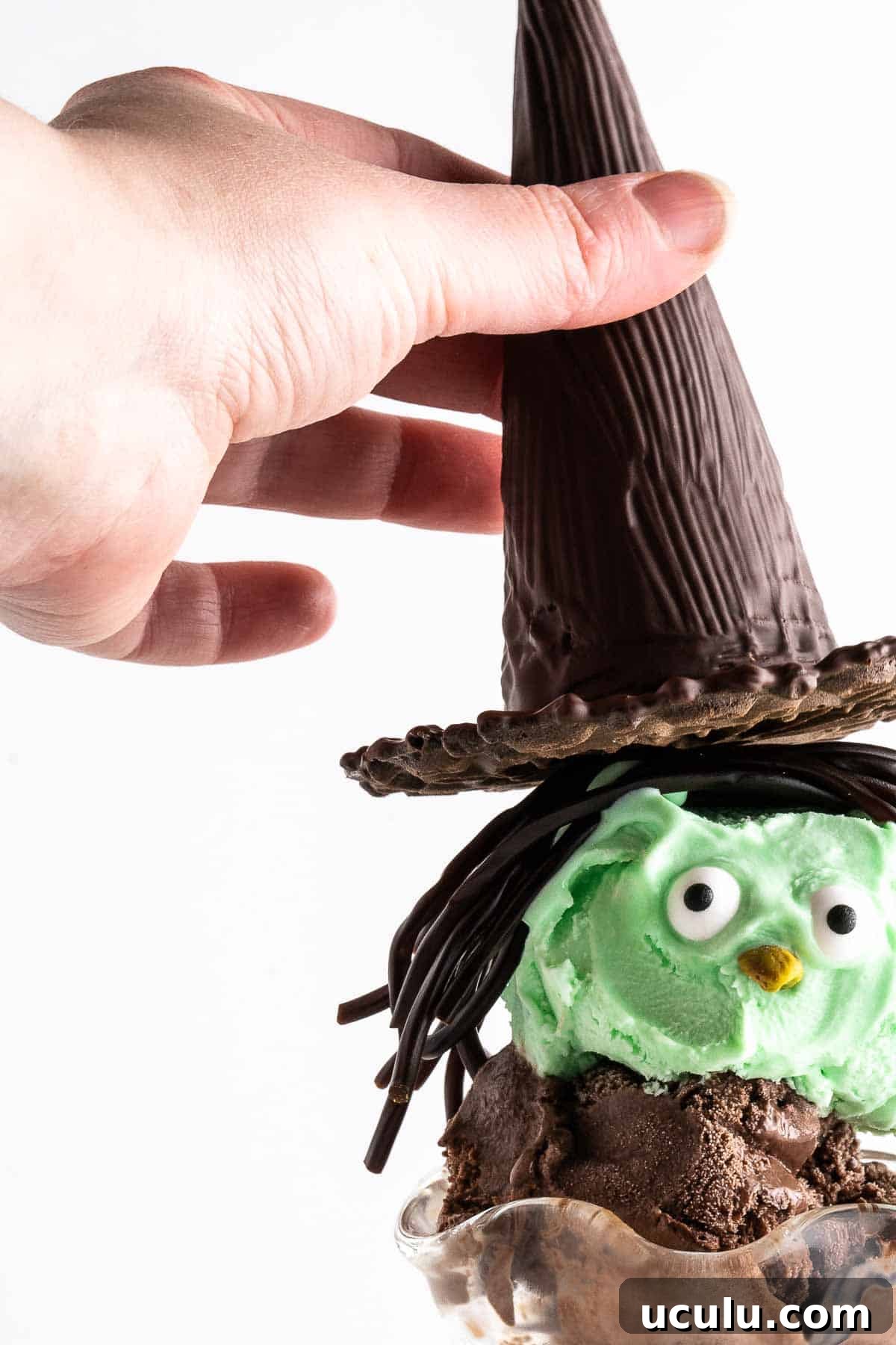 hand placing chocolate witch hat on sundae