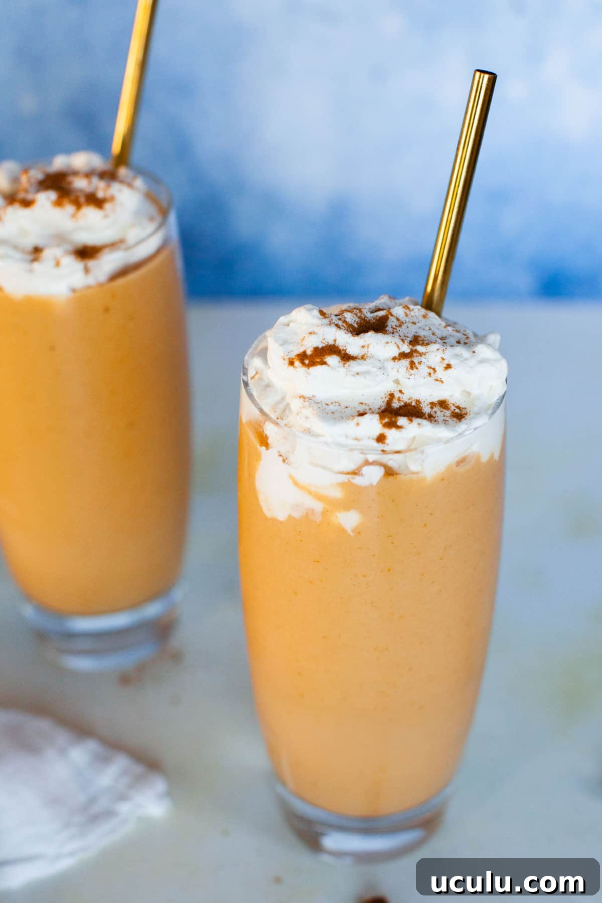 Pumpkin smoothies is tall glasses.