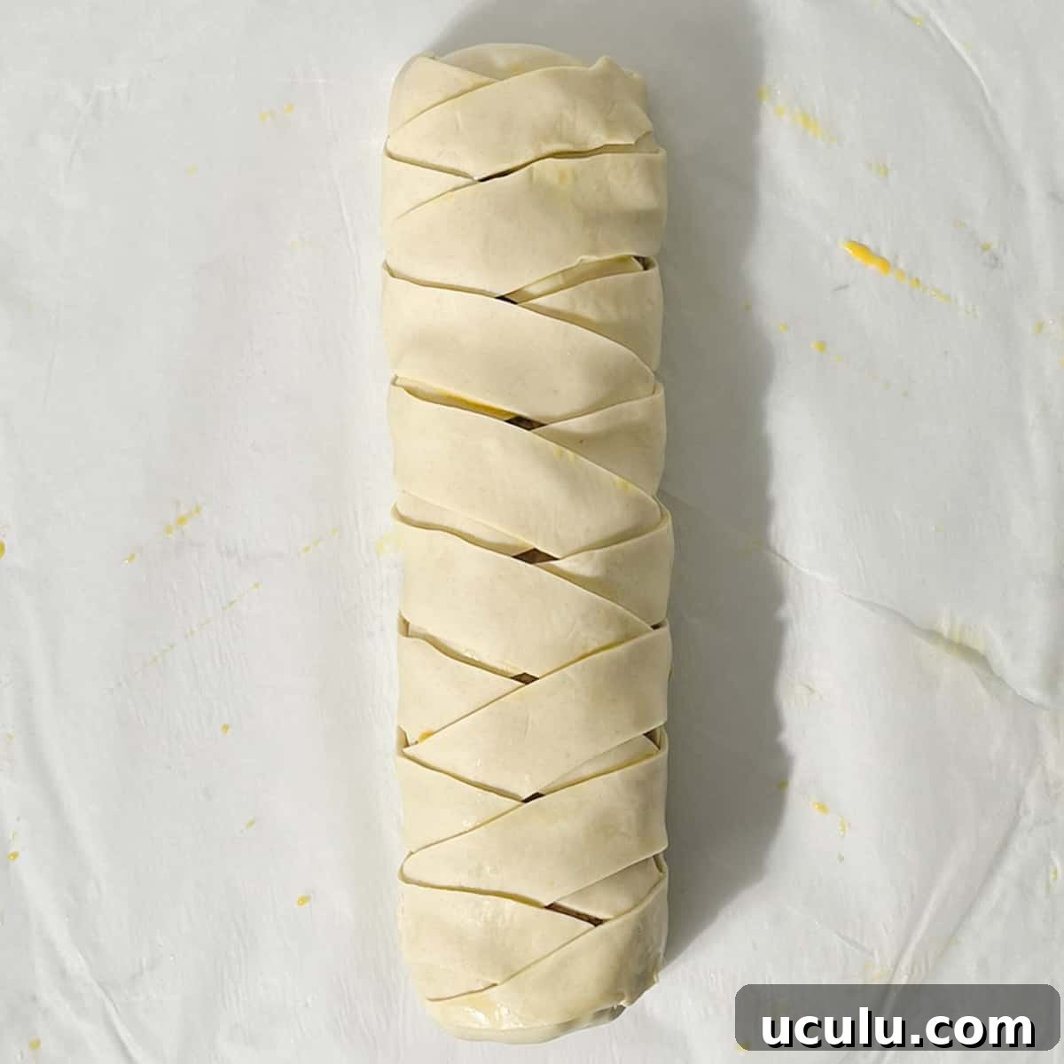 A fully plaited, unbaked sausage roll.