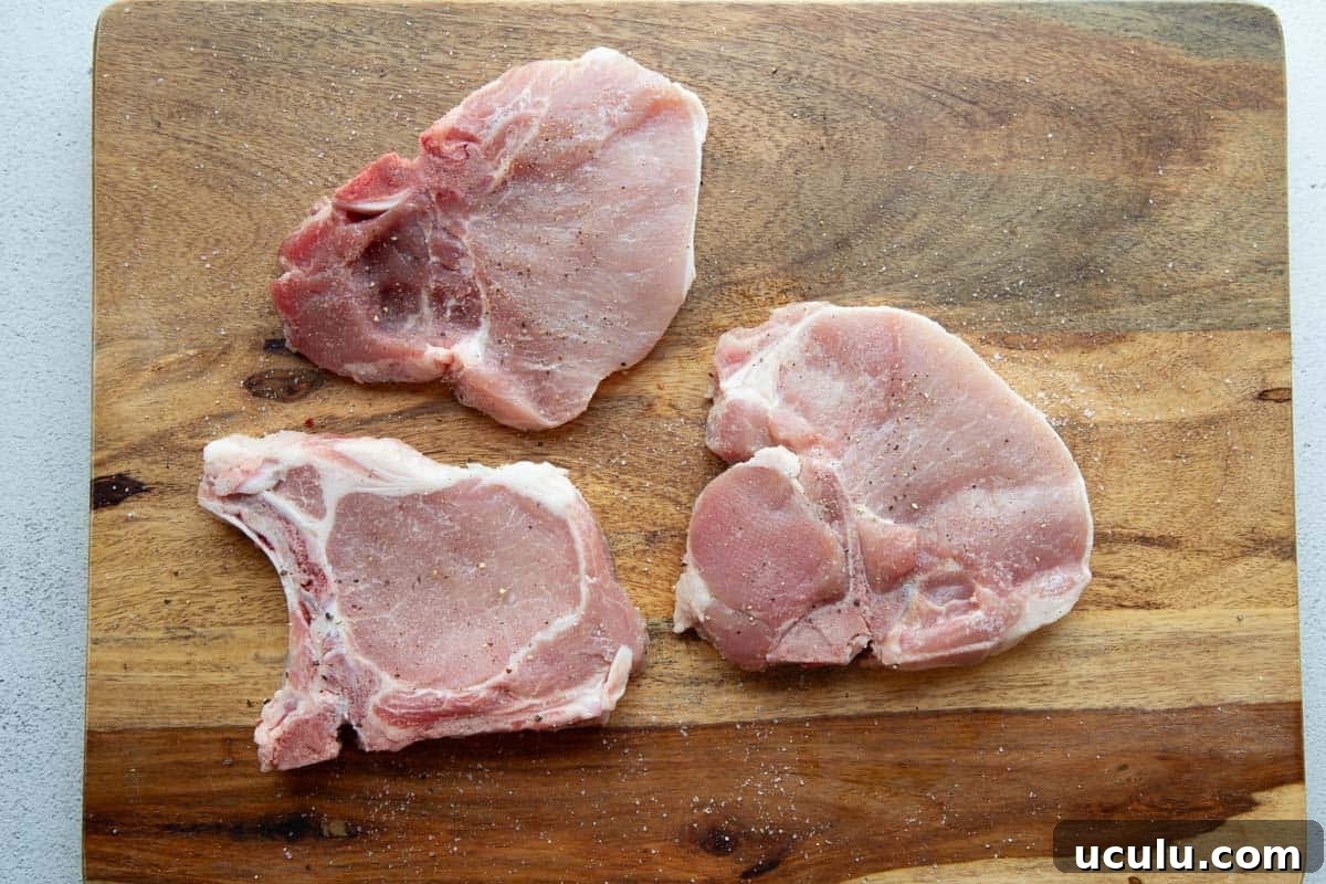 raw pork chops with salt and pepper.