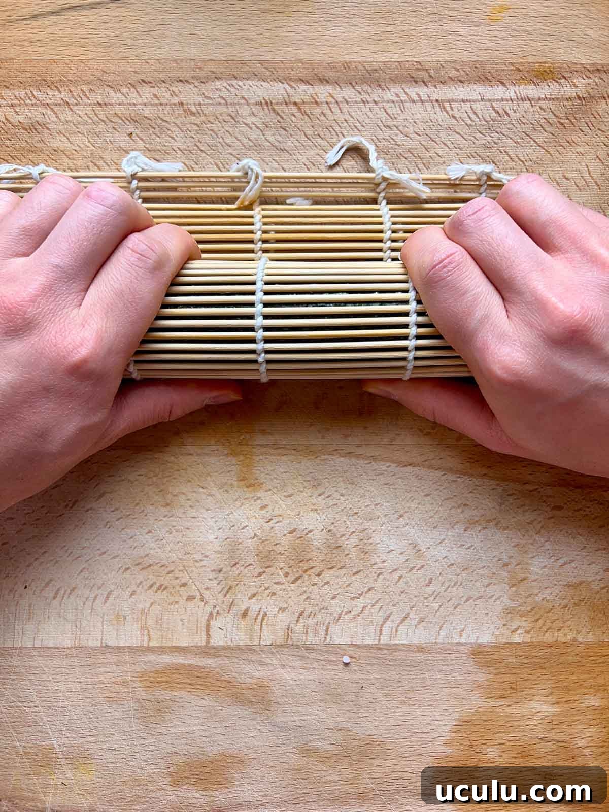 squeezing kimbap between bamboo mat