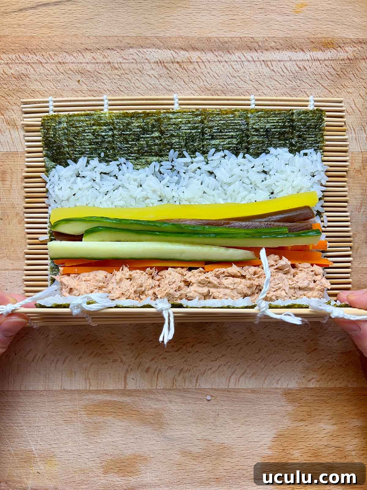 start of rolling kimbap between bamboo mat