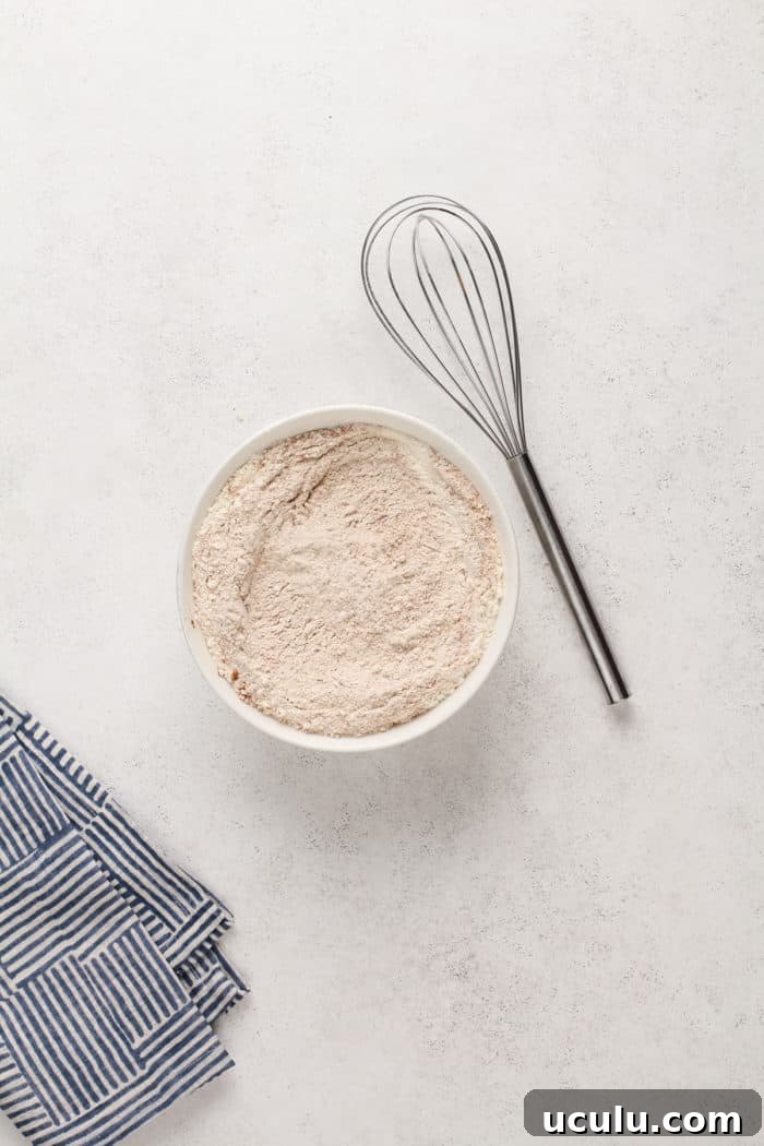 Dry ingredients for carrot cake whisked together in a bowl.