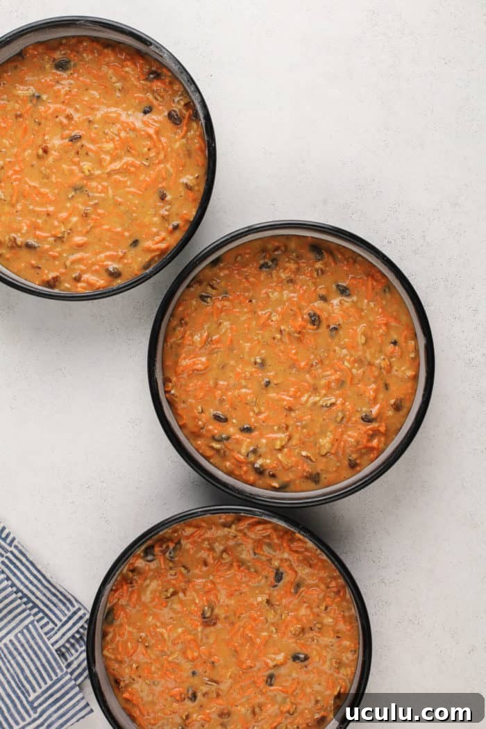 Carrot cake batter in 3 cake pans, ready to go in the oven.