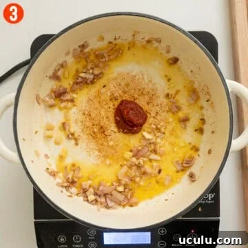 Sauteing garlic and tomato paste with shallots.