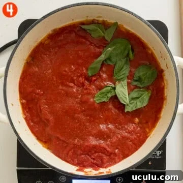 Simmering crushed tomatoes, basil and salt.