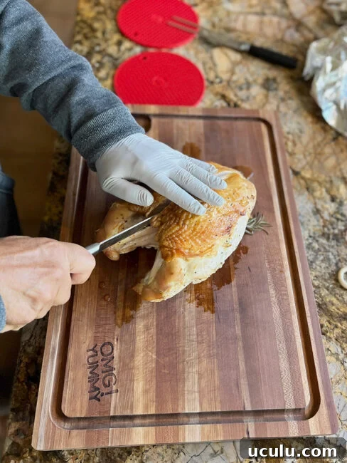 Removing the turkey breast from the bone for slicing.