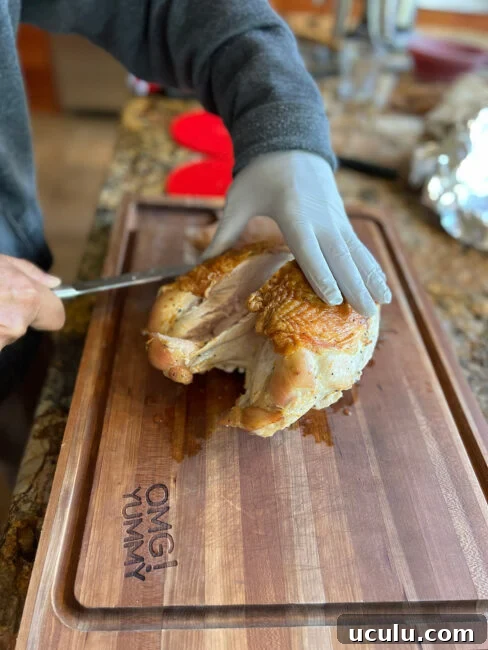 Removing the first half of the turkey breast from the bone for slicing.