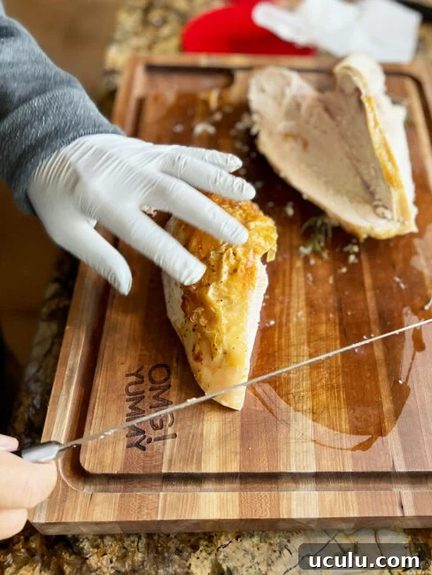 Slicing a piece of the turkey breast after it is removed from the bone.