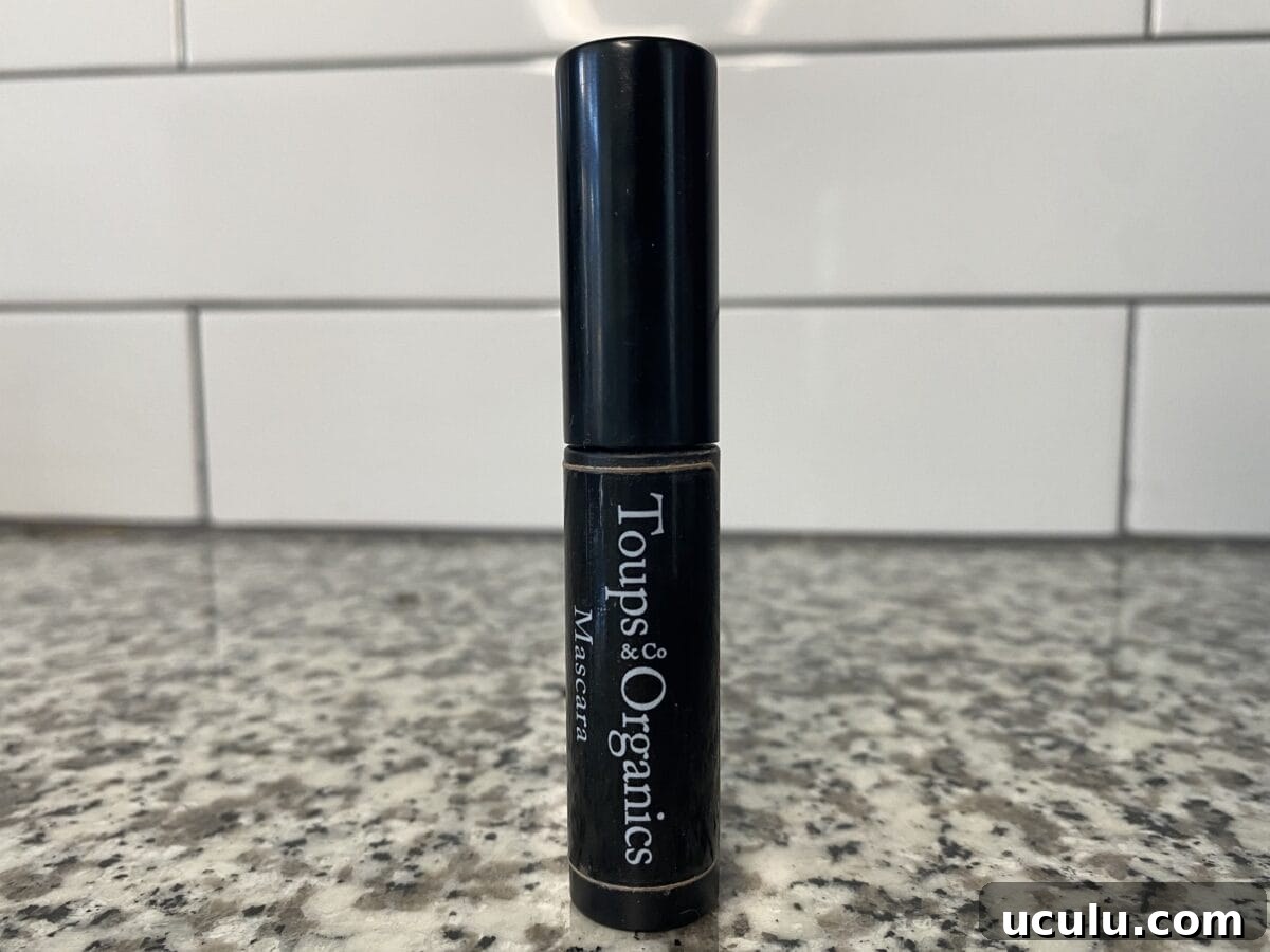 a closed bottle of toups & co mascara sitting on the bathroom counter