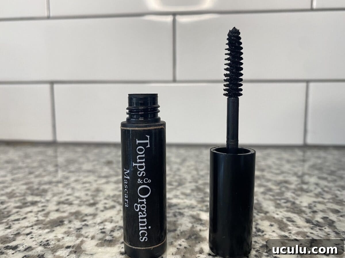 an open bottle of toups & co mascara sitting on the counter with the brush sitting next to the bottle