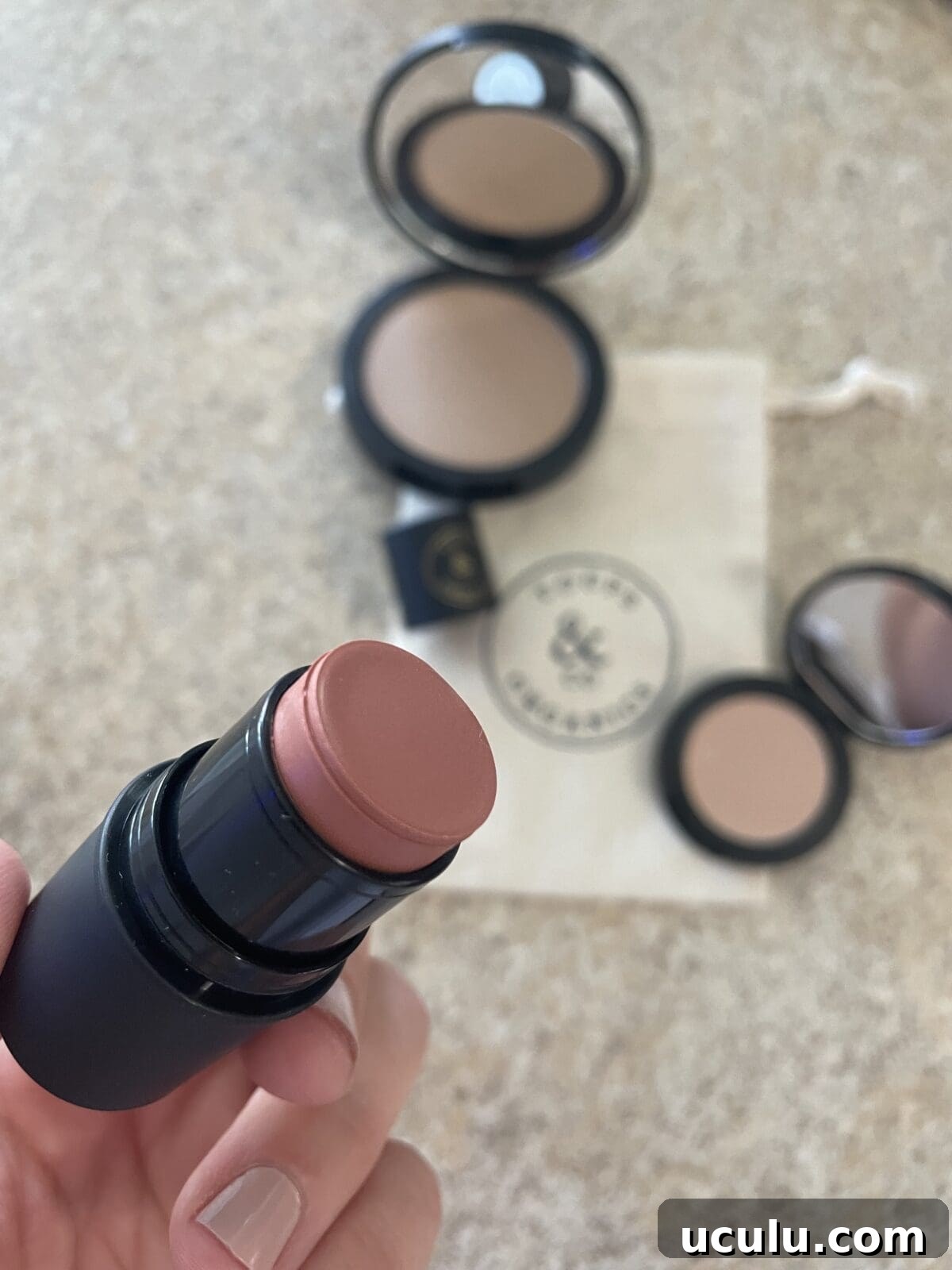 a person holding a cream cheek tint