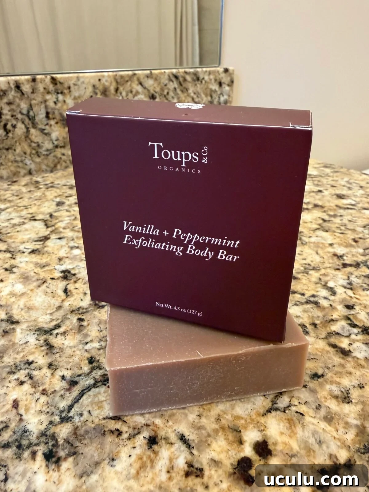 A box labeled “Toups & Co Organics Vanilla + Peppermint Exfoliating Body Bar” sits on a granite countertop.