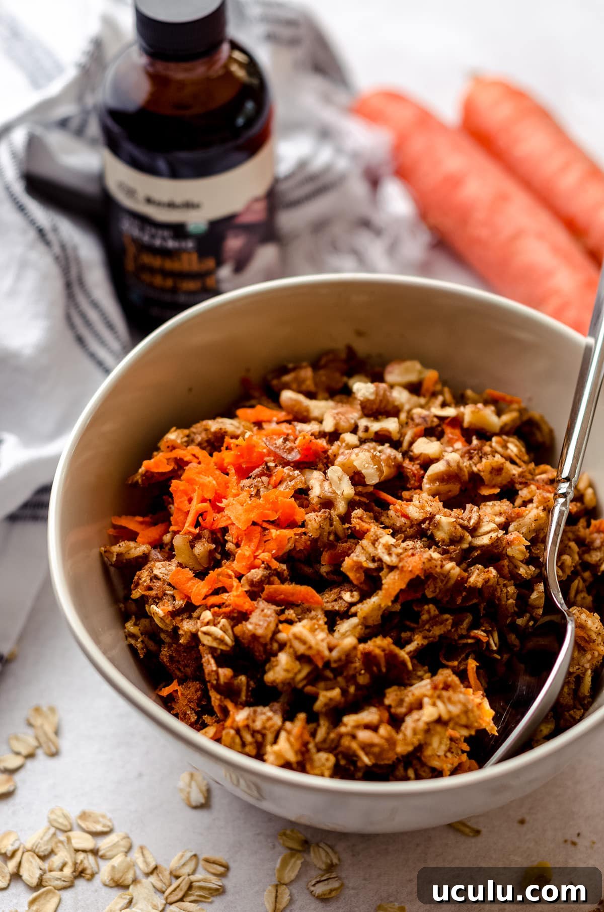 carrot cake baked oatmeal in a bowl with a spoon