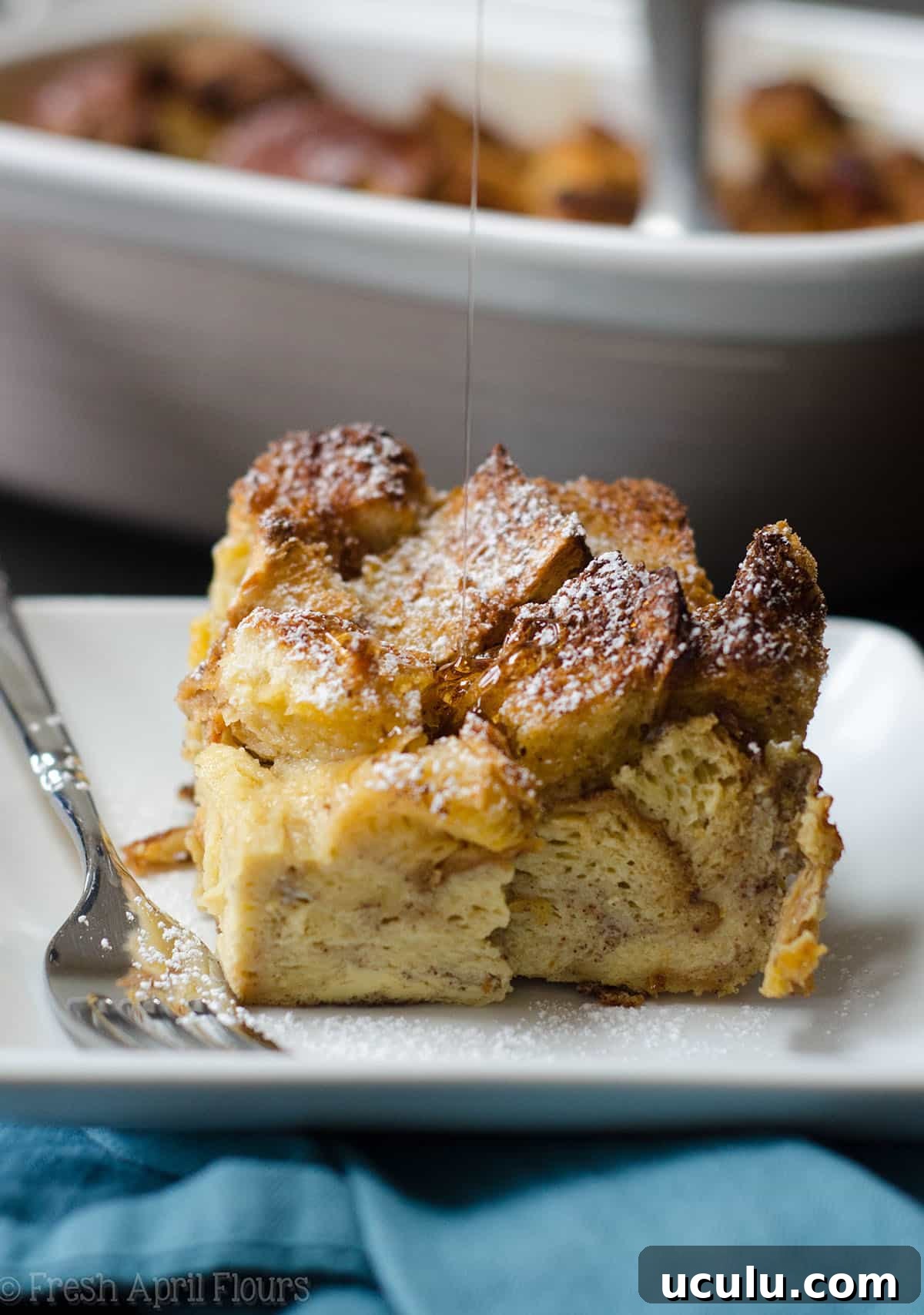 french toast casserole on a plate with syrup dripping onto it