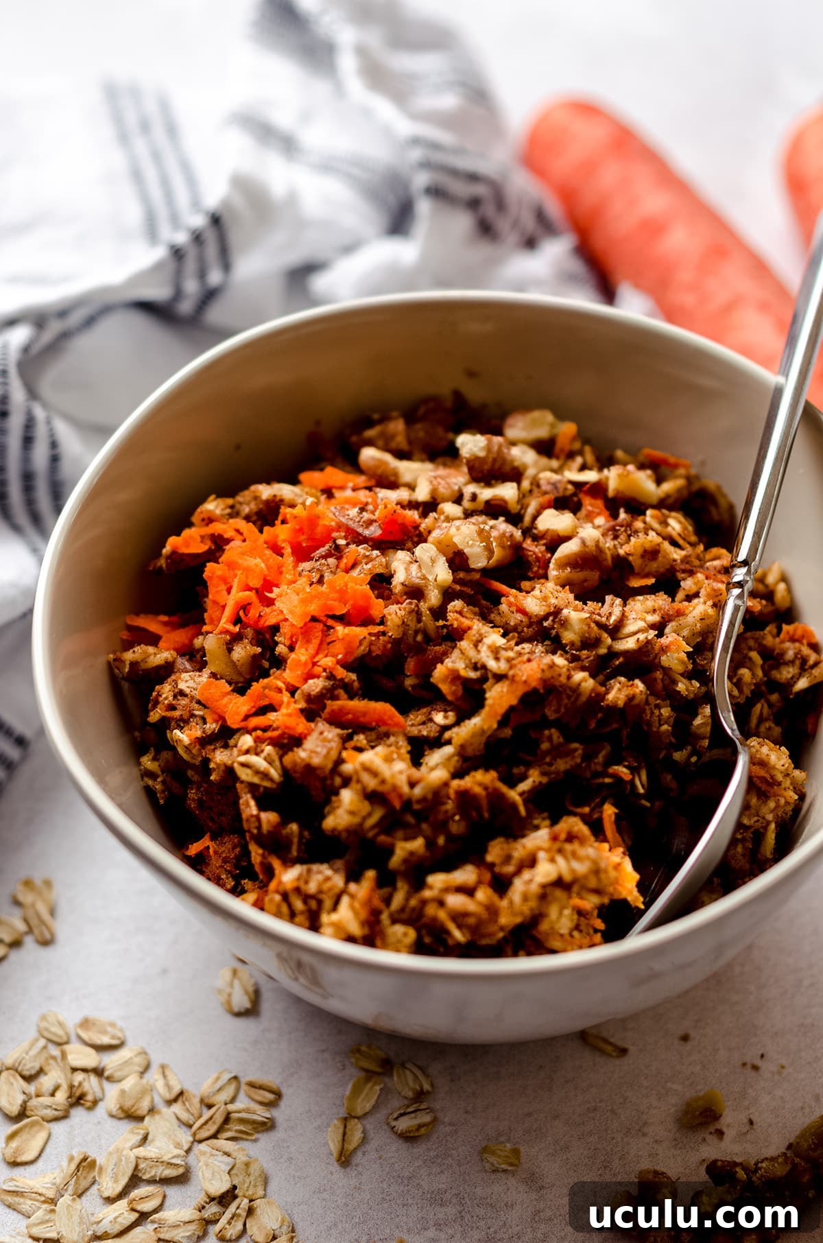 carrot cake baked oatmeal in a bowl with a spoon