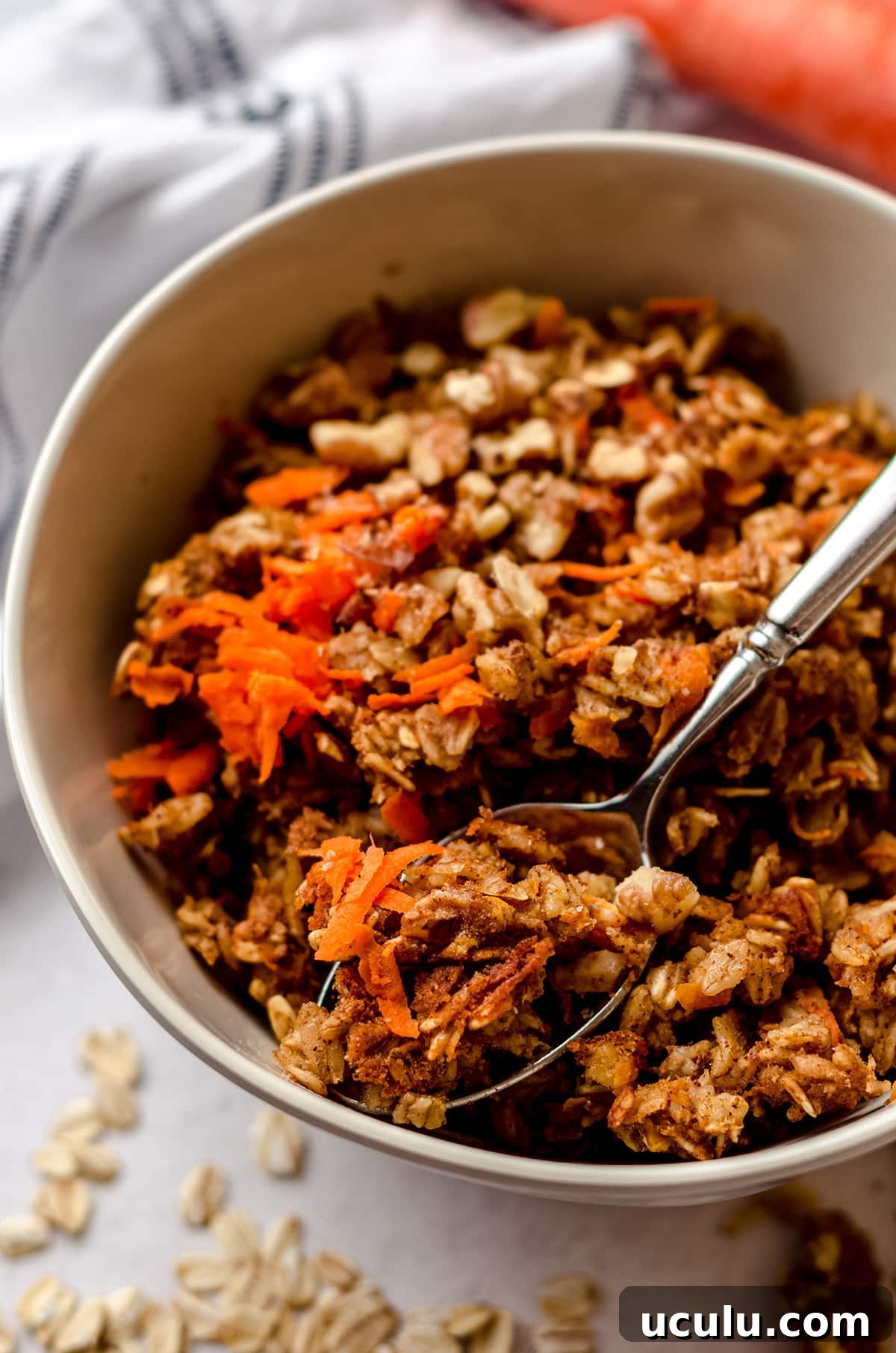 carrot cake baked oatmeal in a bowl with a spoon