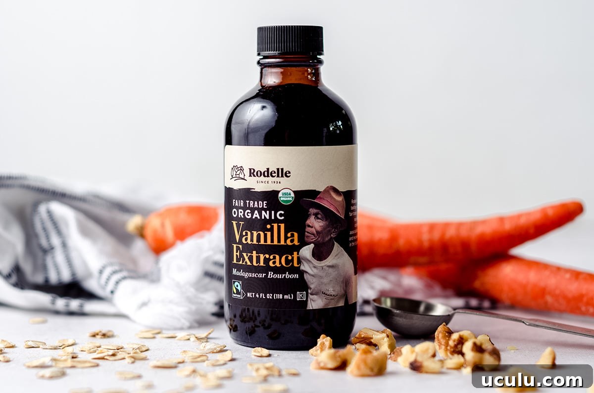 bottle of vanilla extract with carrots, walnuts, and oats around it