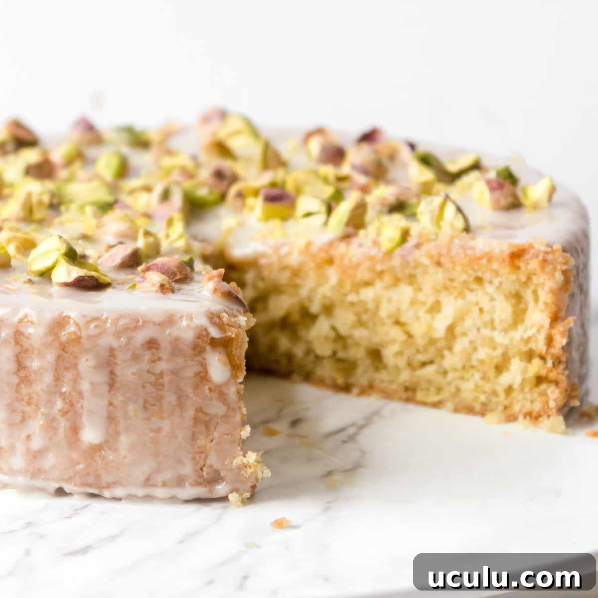 vegan olive oil cake on a platter with a slice cut out