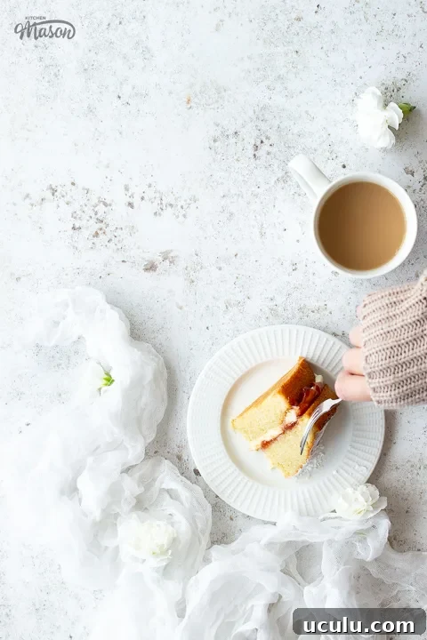 Someone having a slice of cake and a cup of tea