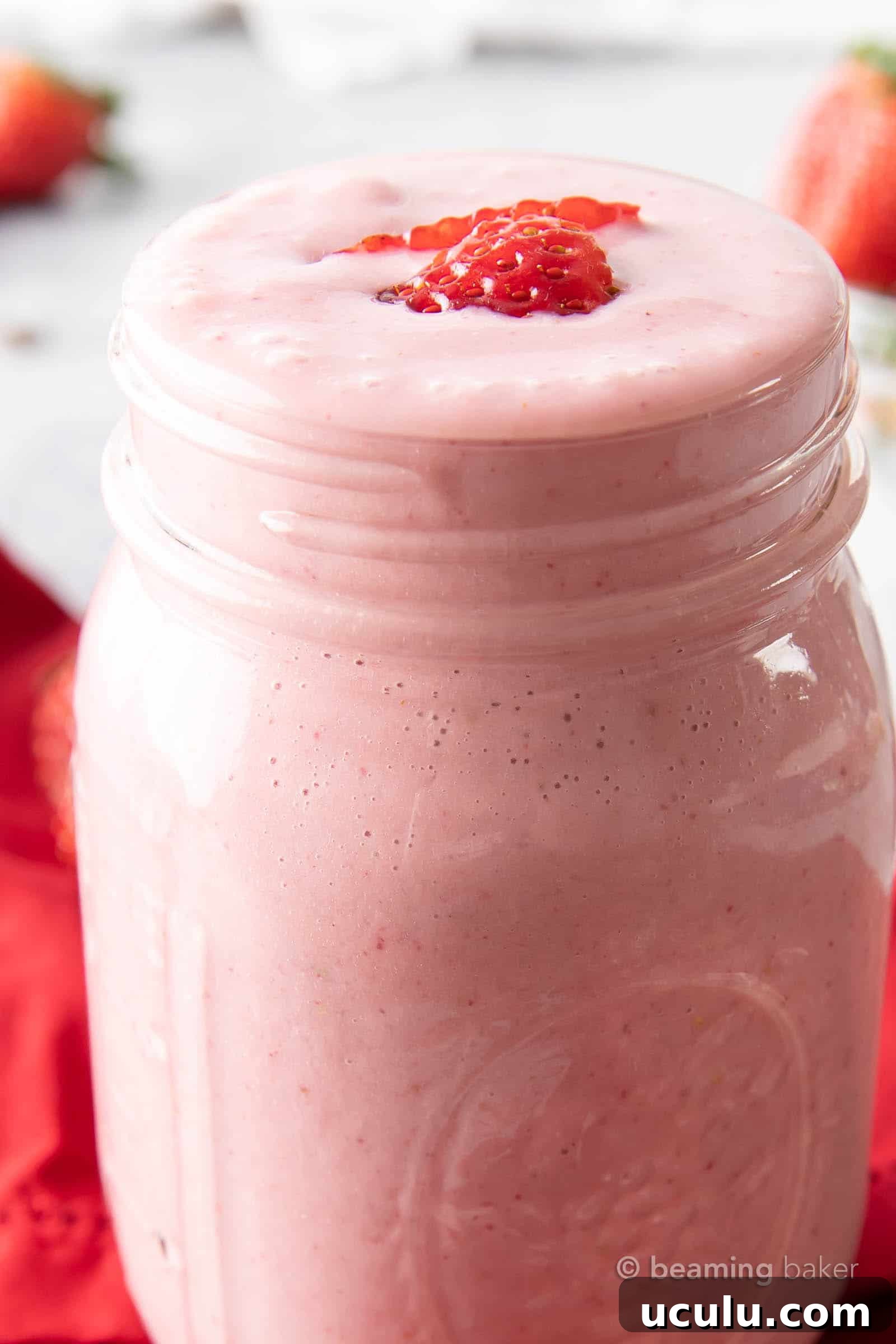Closeup of mason jar filled with strawberry shake.