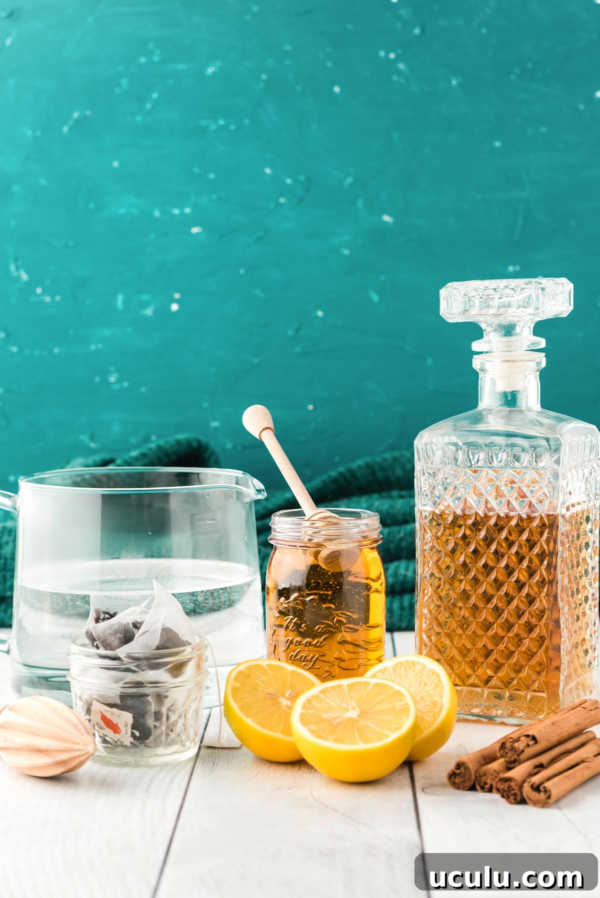 Ingredients to make a hot toddy on a white wood table.
