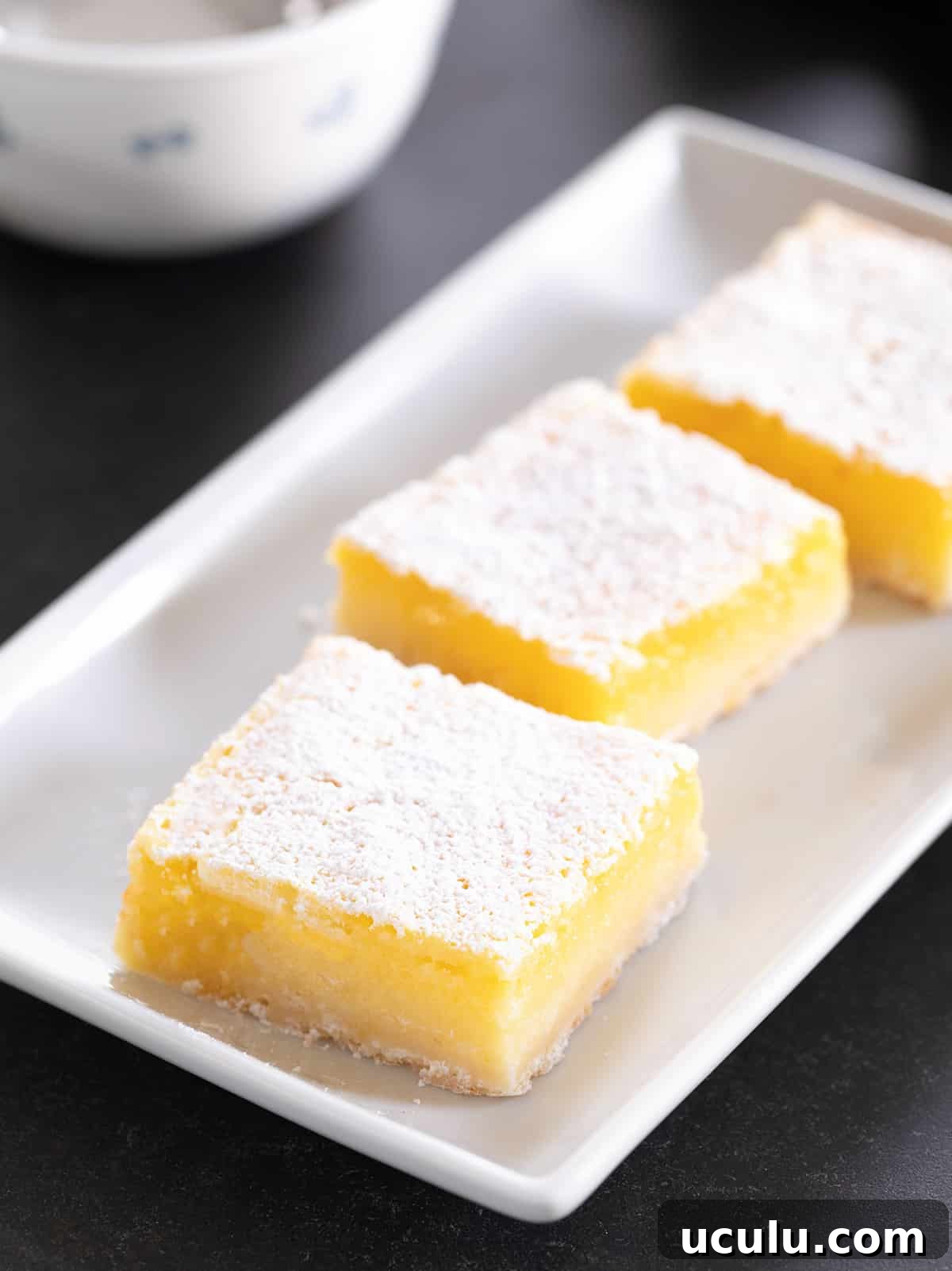 Three lemon bars on a white platter