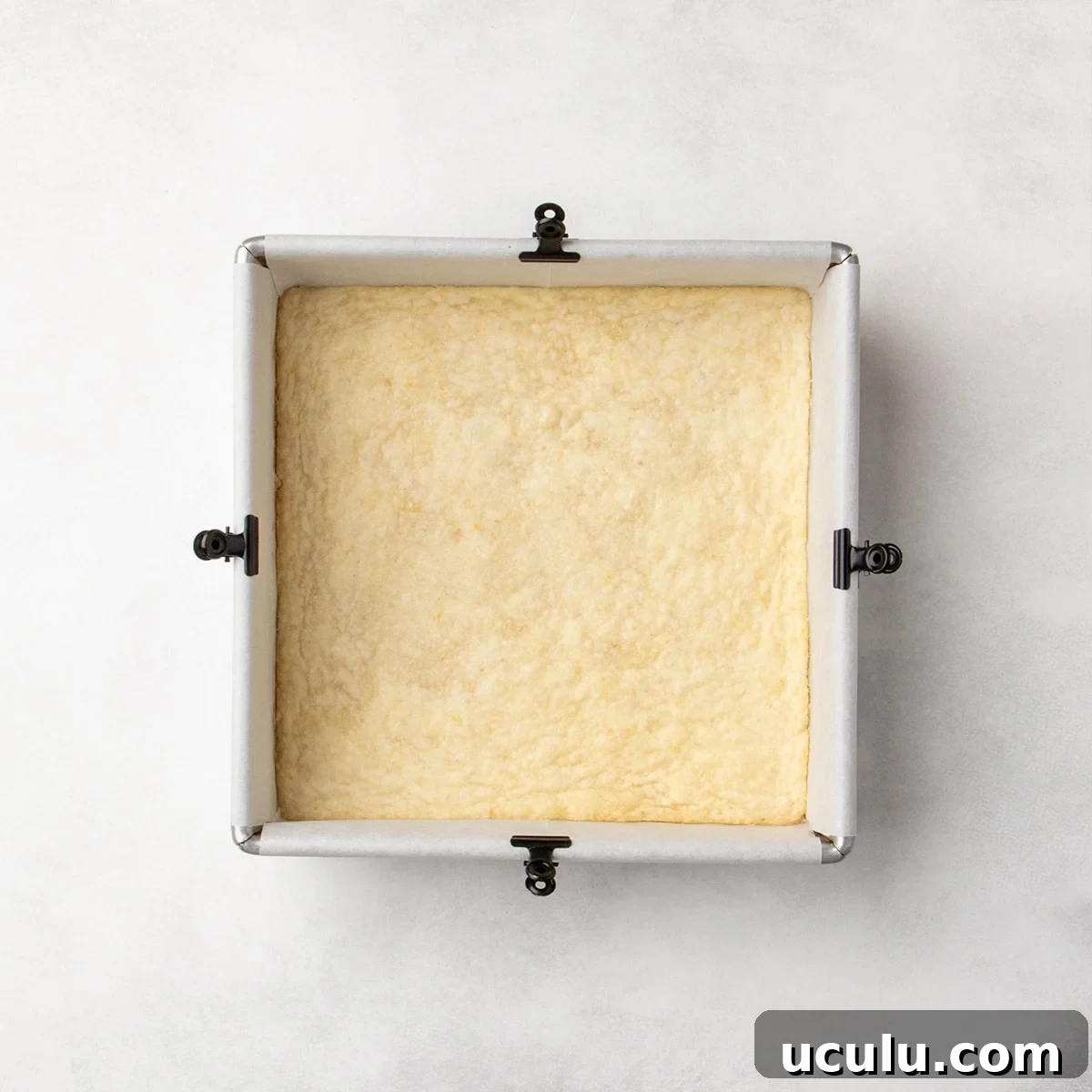 Baked pale yellow crust in a square pan, with very lightly golden color on the edges.