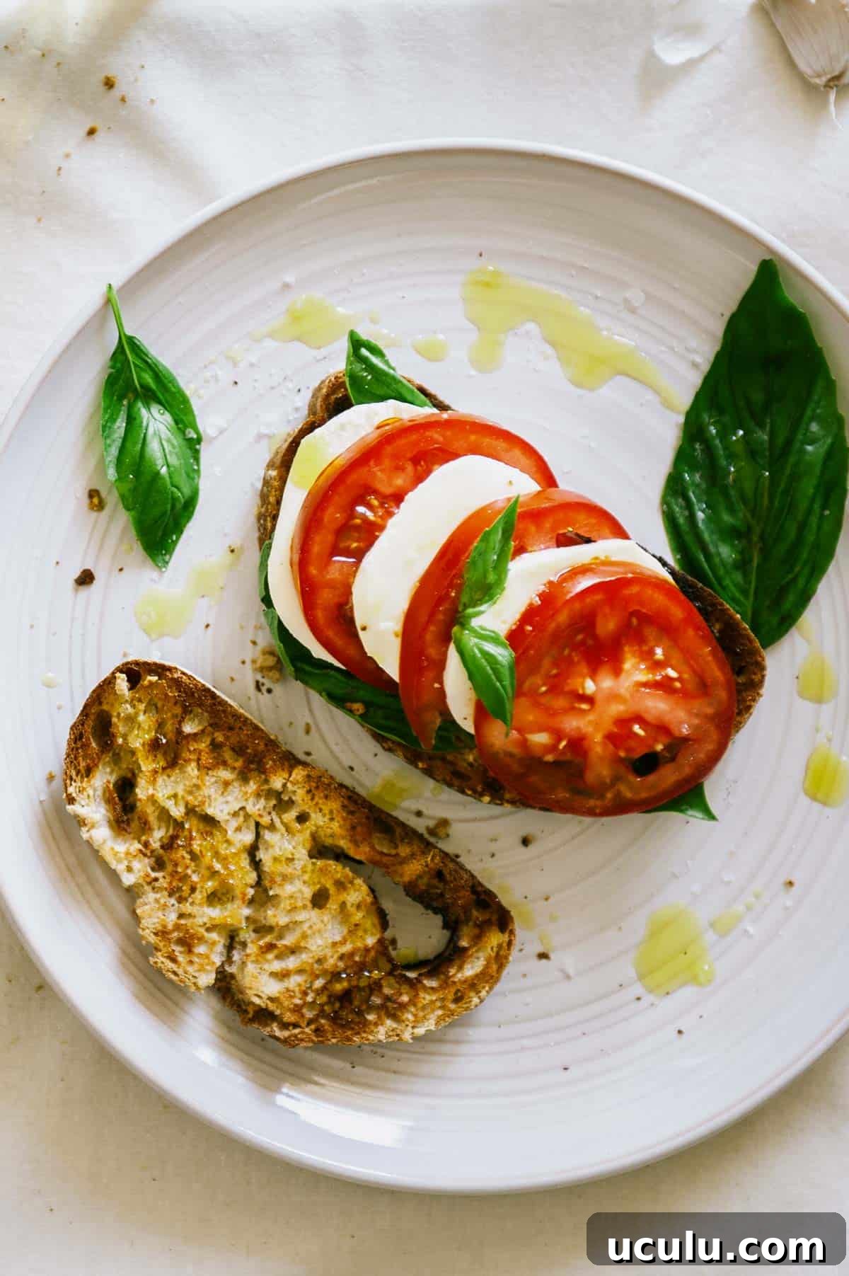 overhead view of caprese bruschetta with olive oil drizzle.