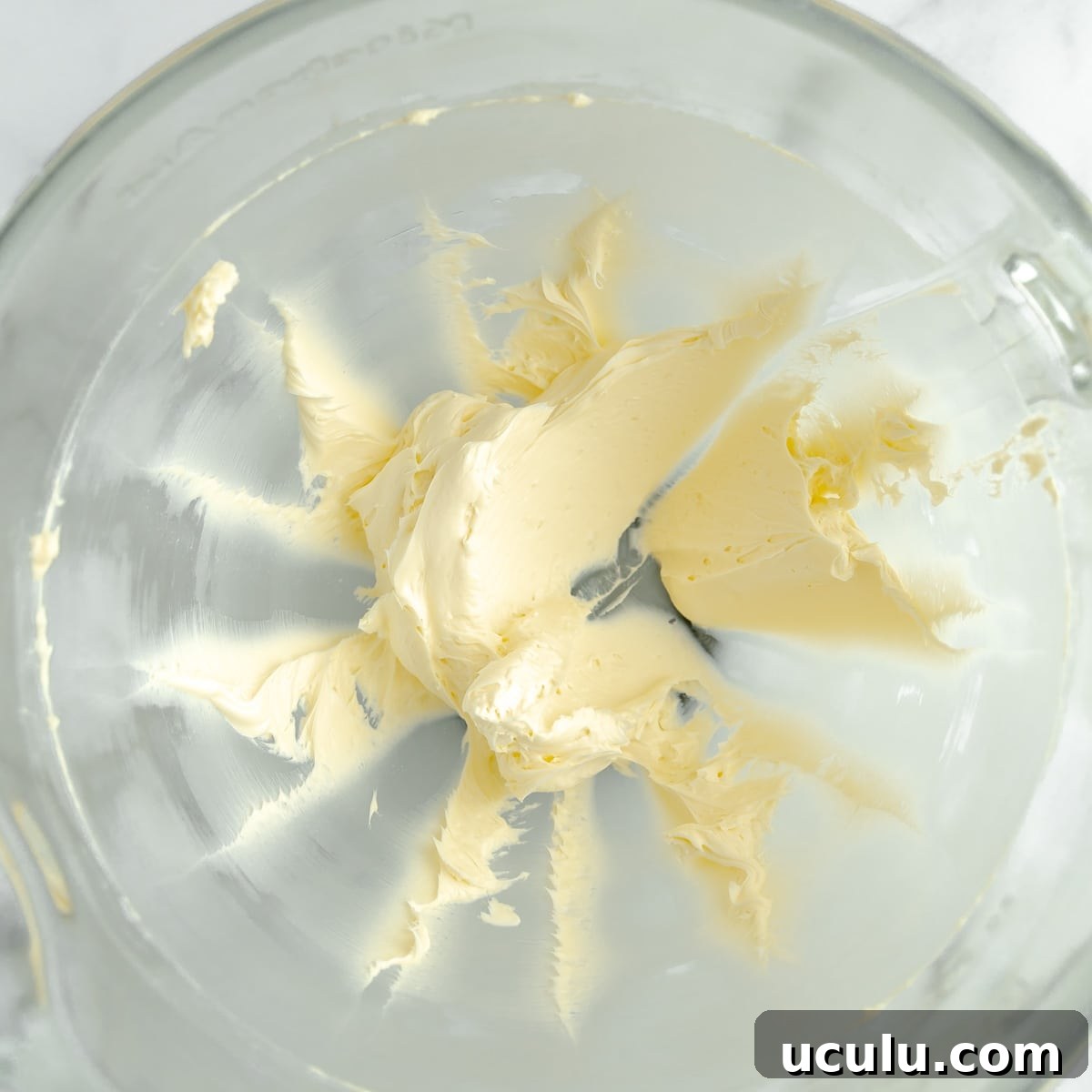 Creamed butter in a glass mixing bowl.