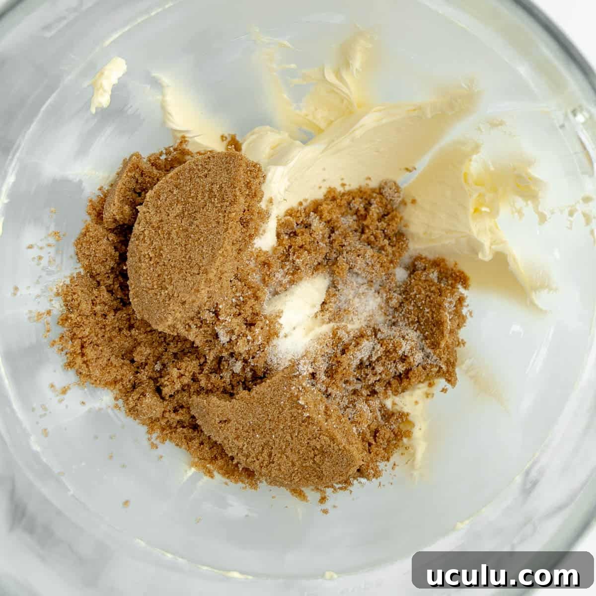 Sugar and butter added to a mixing bowl.