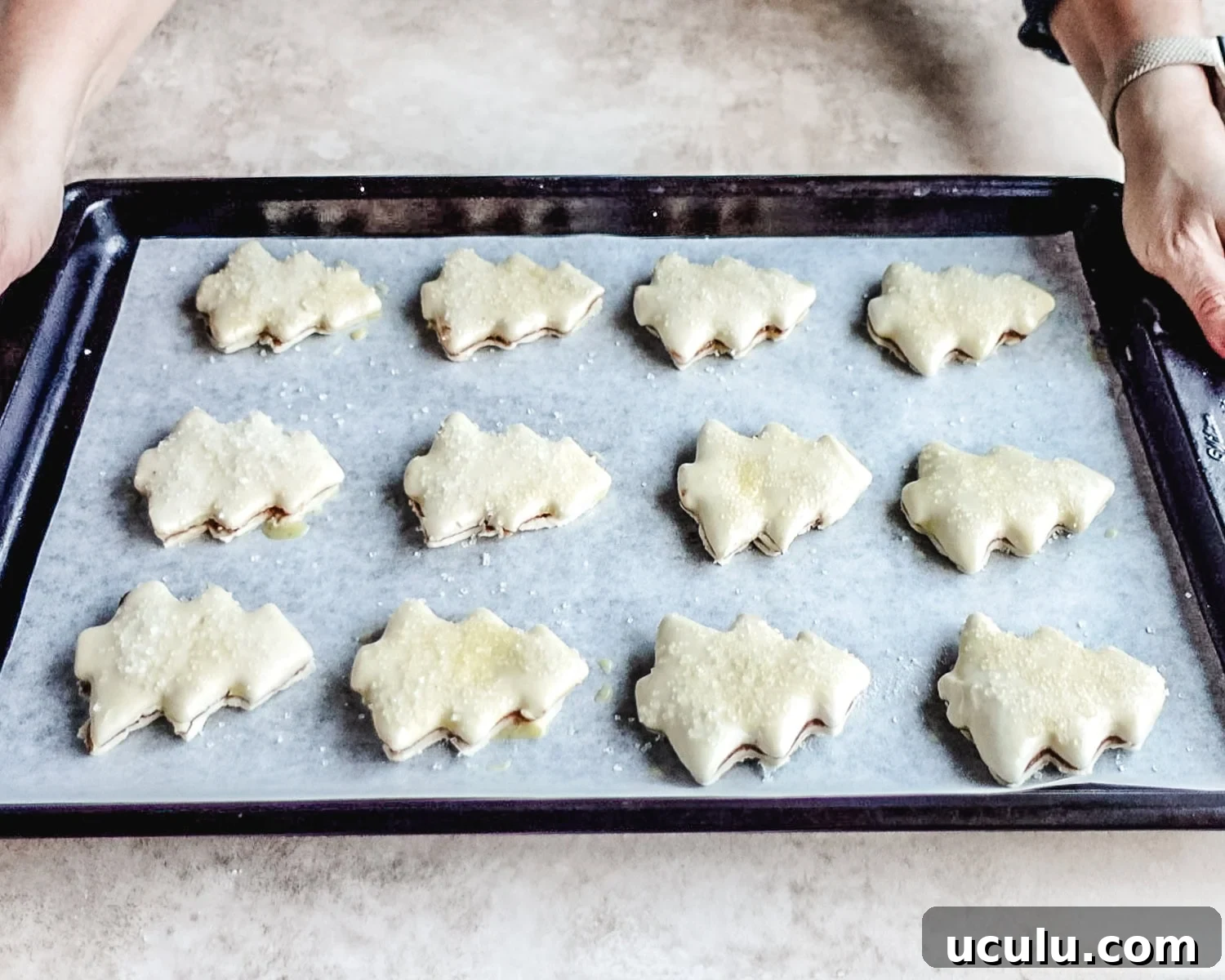 Bake the prepared puff pastry Christmas trees in the preheated oven.