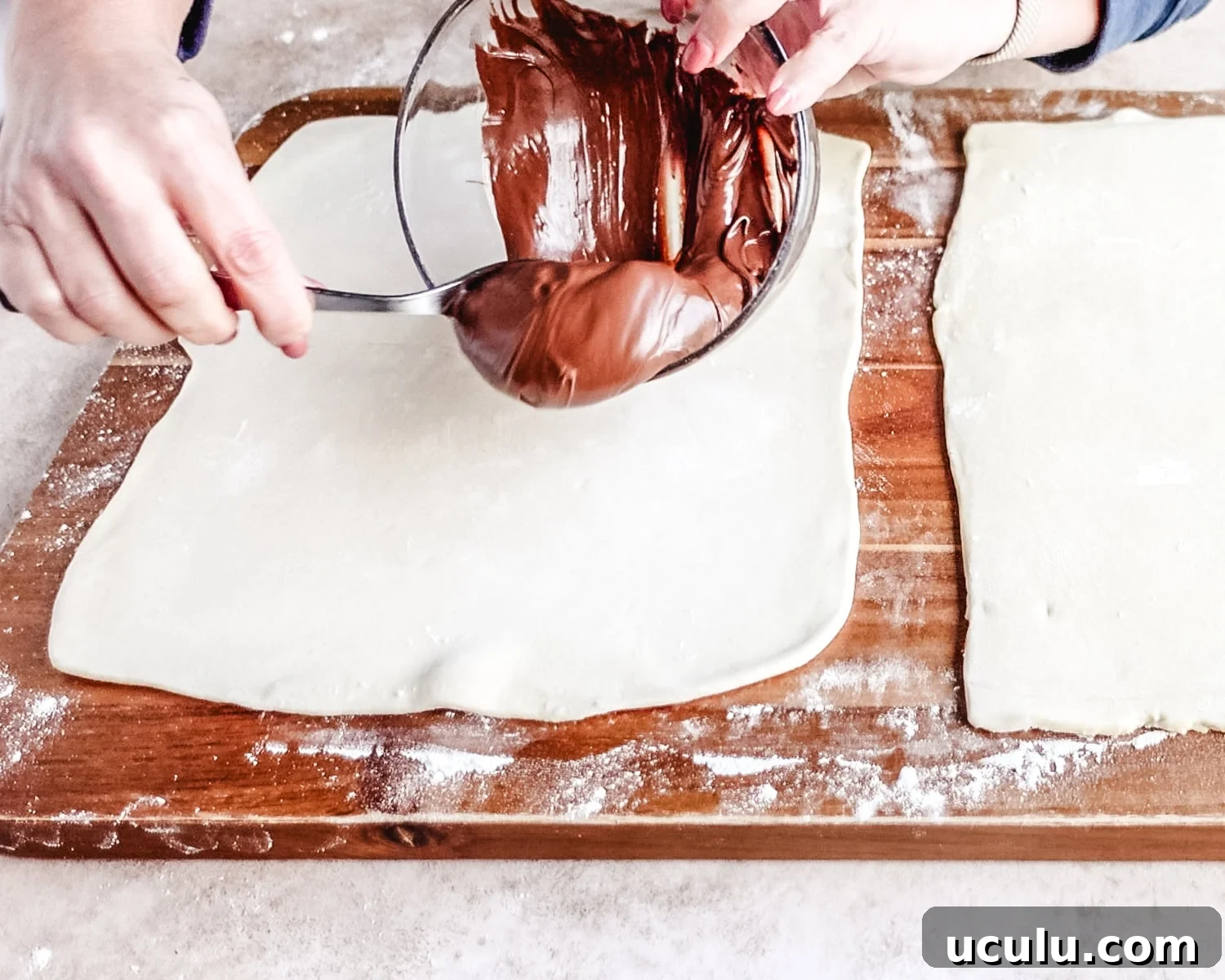 Top one sheet of puff pastry with nutella.