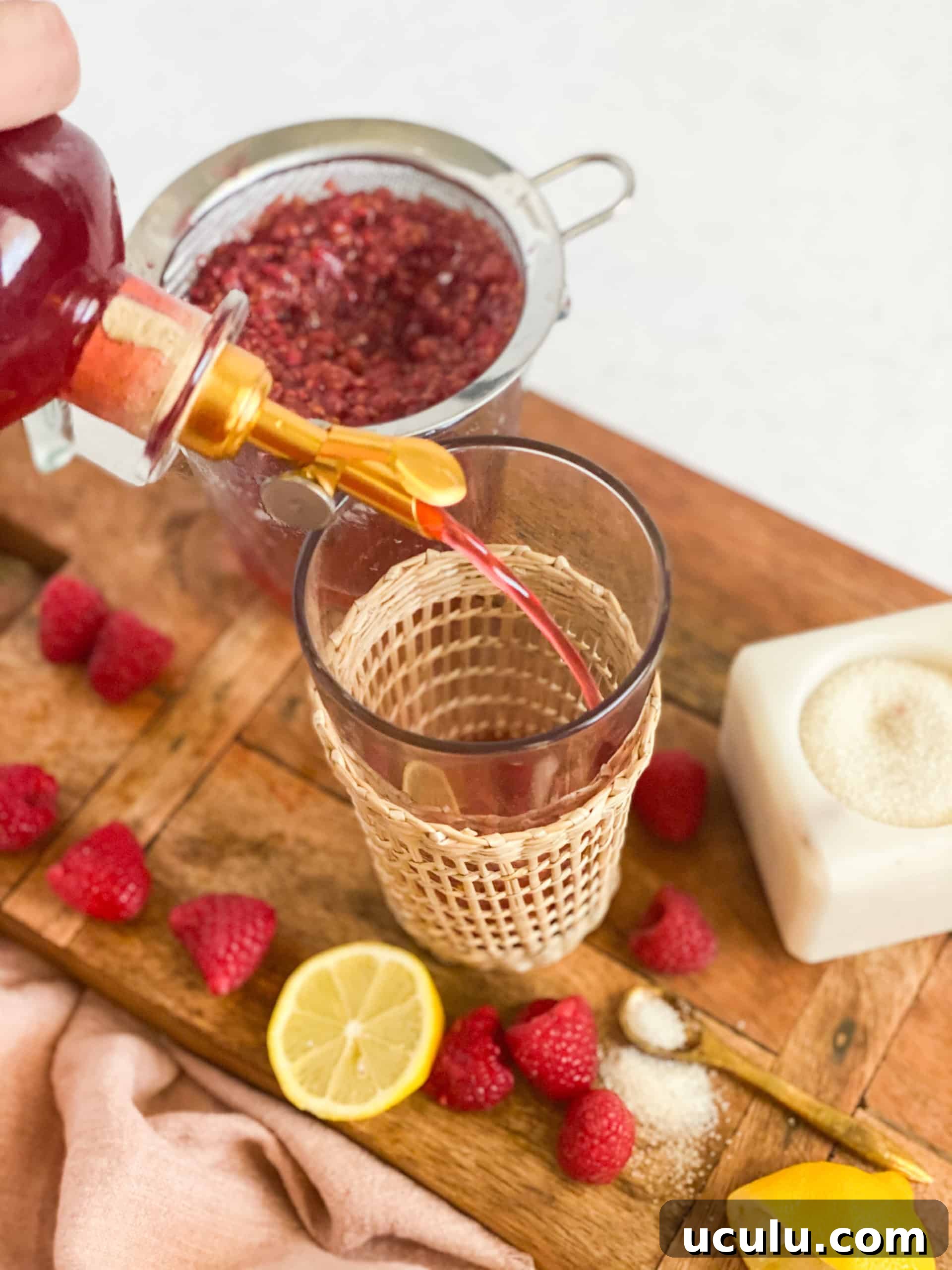 Raspberry Simple Syrup being poured into a glass