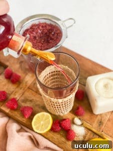 Raspberry Simple Syrup being poured into a glass