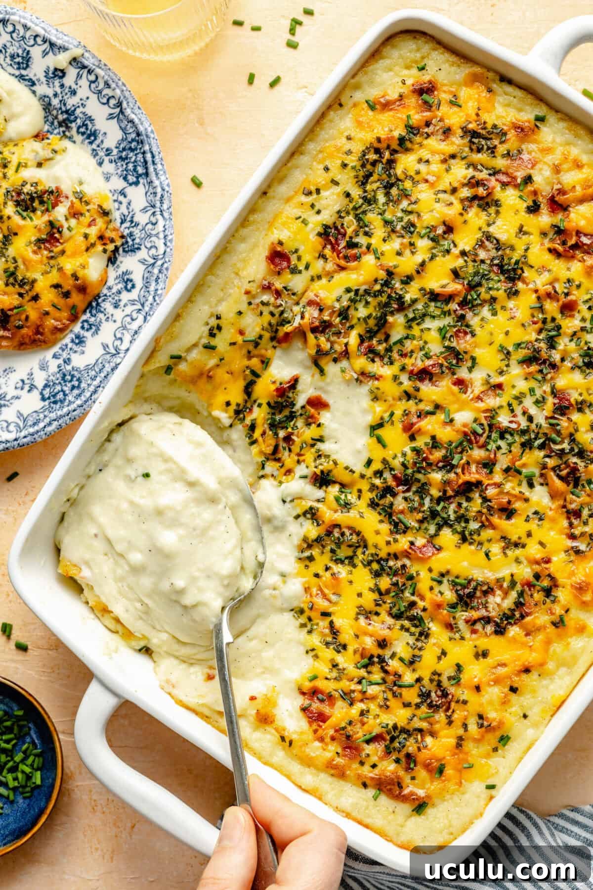 GoGo’s Party Potatoes in baking dish. Scoop being pulled out.