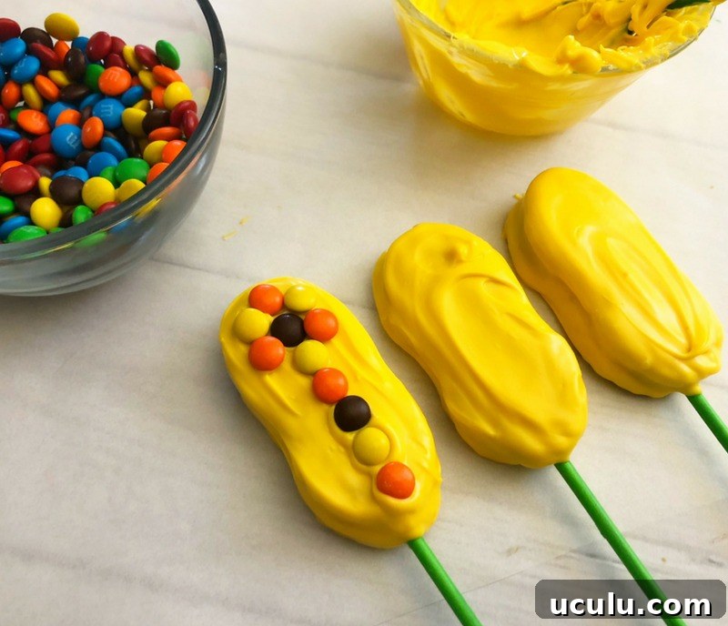 Assembling dipped nutter butters to create Indian Corn Harvest Cookies.