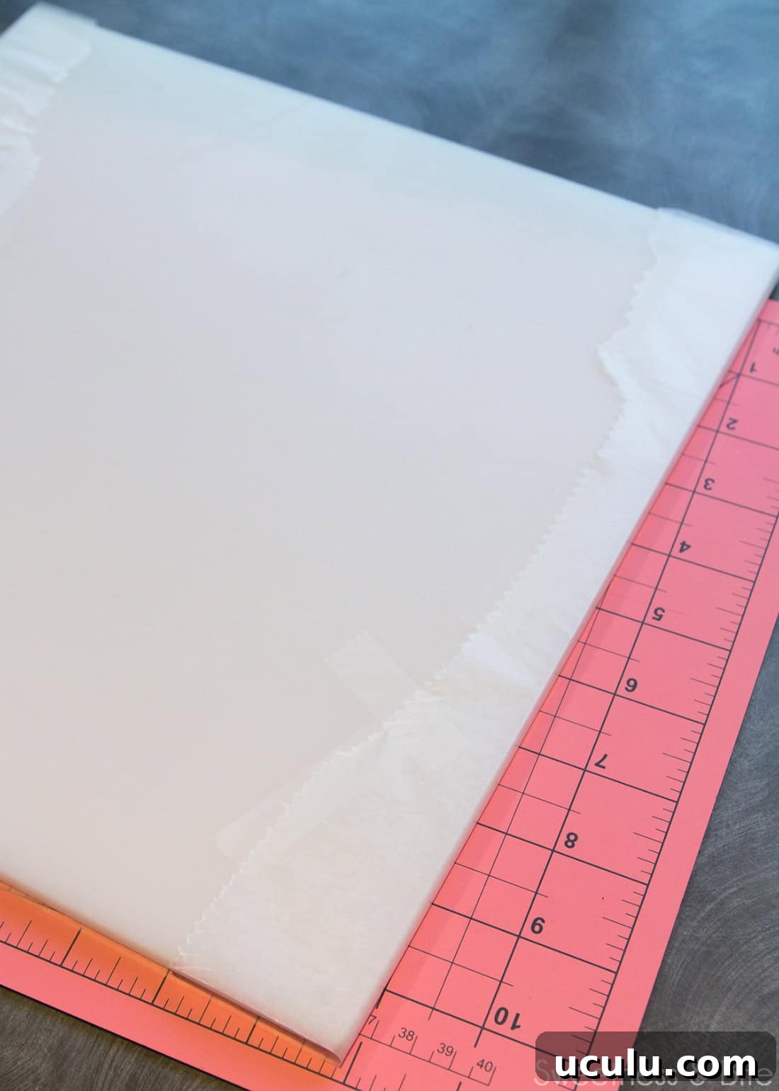 A cake board with waxed paper wrapped around it and taped on the underside.
