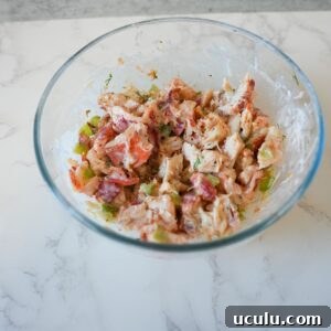 Lobster mixed with celery, mayo and herbs in a bowl.