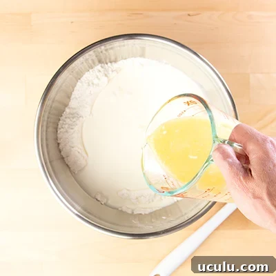 Sheet pan pancake batter pouring in melted butter and eggs