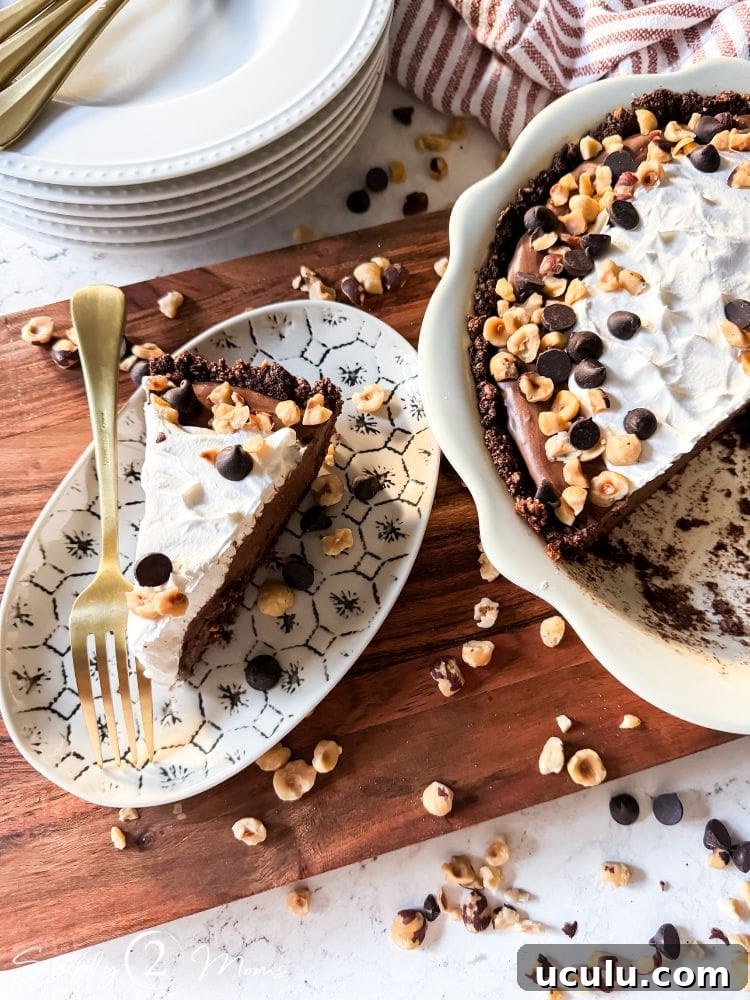 Slice of dairy free nutella pudding pie on a plate next to the pie.